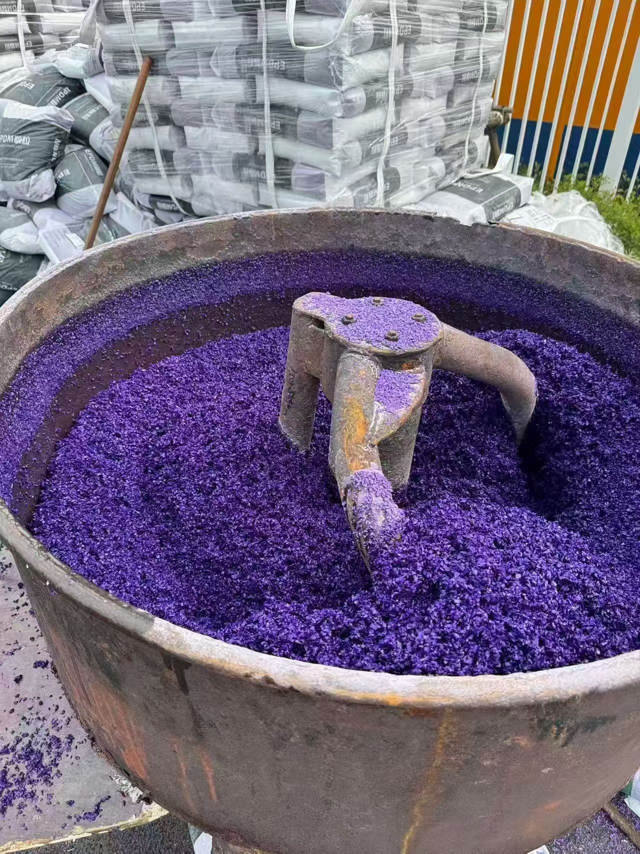 Purple EPDM rubber granules being mixed in an industrial mixer.