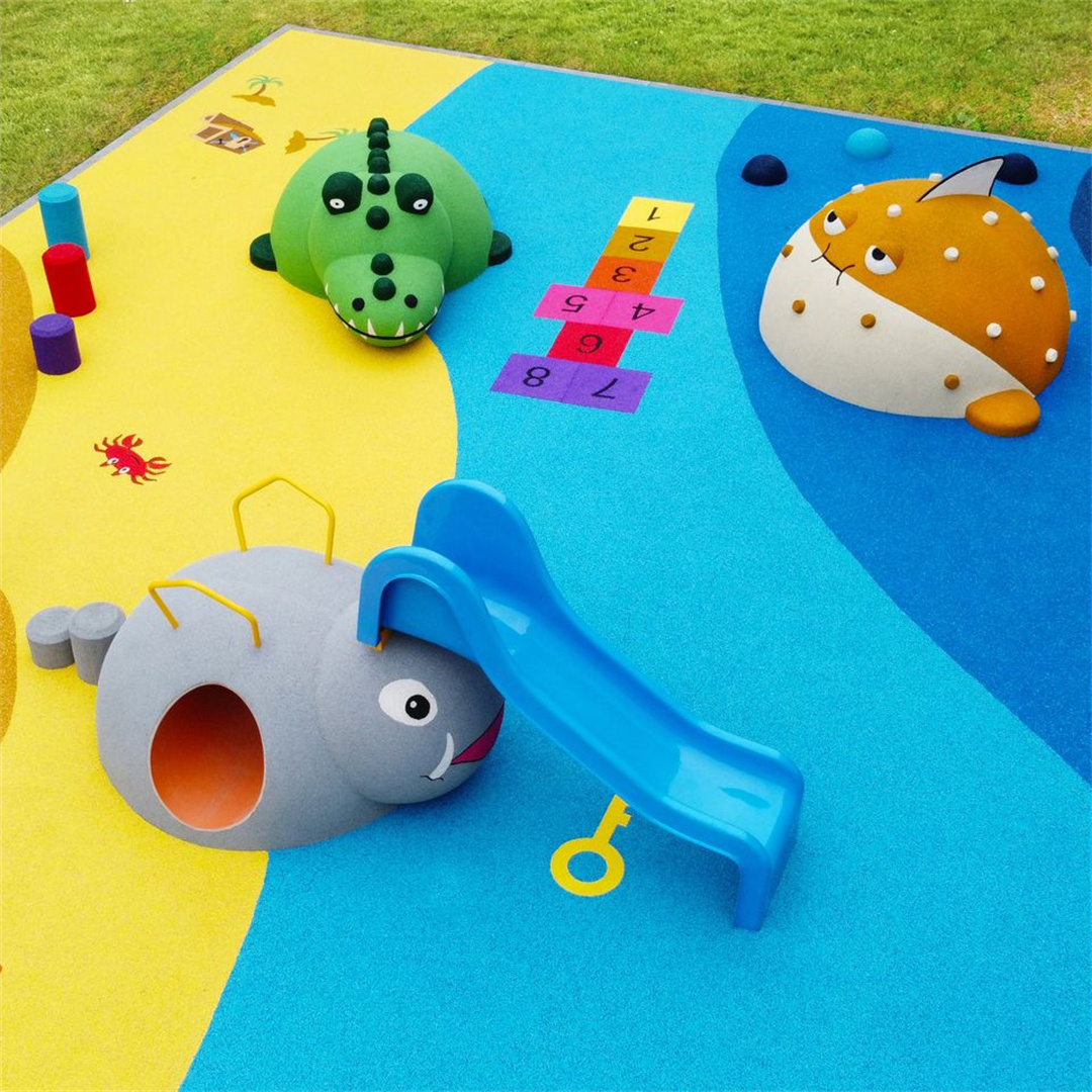 A vibrant EPDM rubber playground surface in yellow and blue, featuring playful animal-shaped play structures — including a green dinosaur, a gray elephant slide, and a spotted orange creature